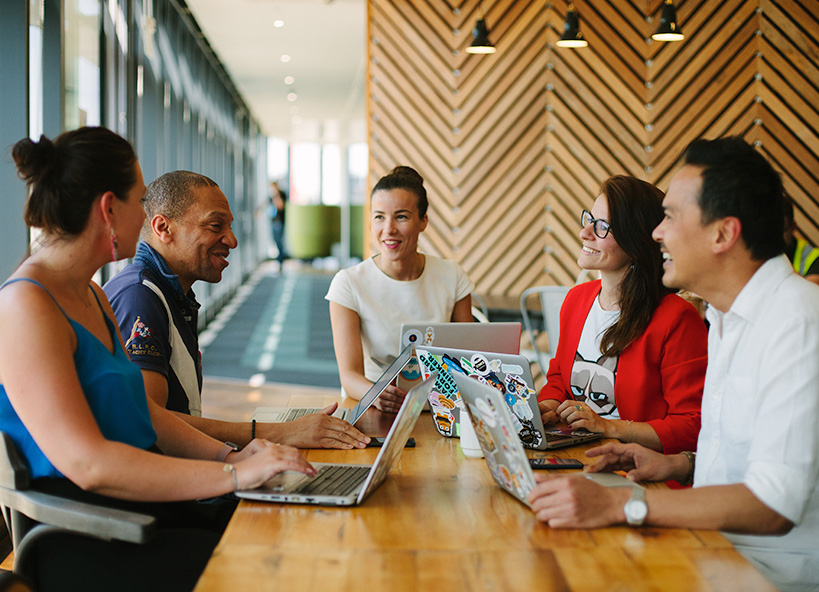 A diverse group of AWS employees works in a common office space.