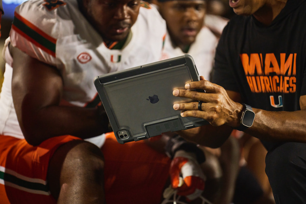 Ein Trainer von Miami überprüft während der Partie mit Spieler:innen an der Seitenlinie Aufnahmen auf dem iPad.
