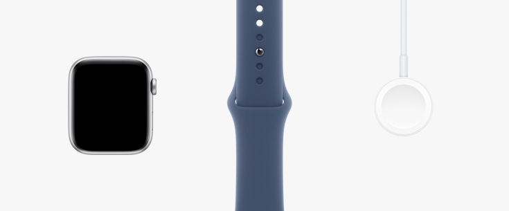 Lined up in a row: front view of Apple Watch SE hardware, a Starlight Sport Band and Magnetic Charger to USB‑C Cable.