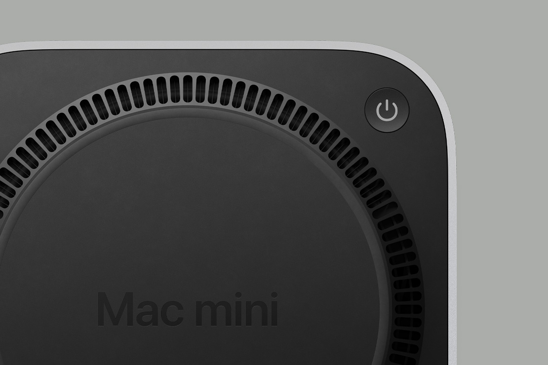 Mac mini 的黑色底部，展示電源按鈕與扇狀排列成圓形的通風架構