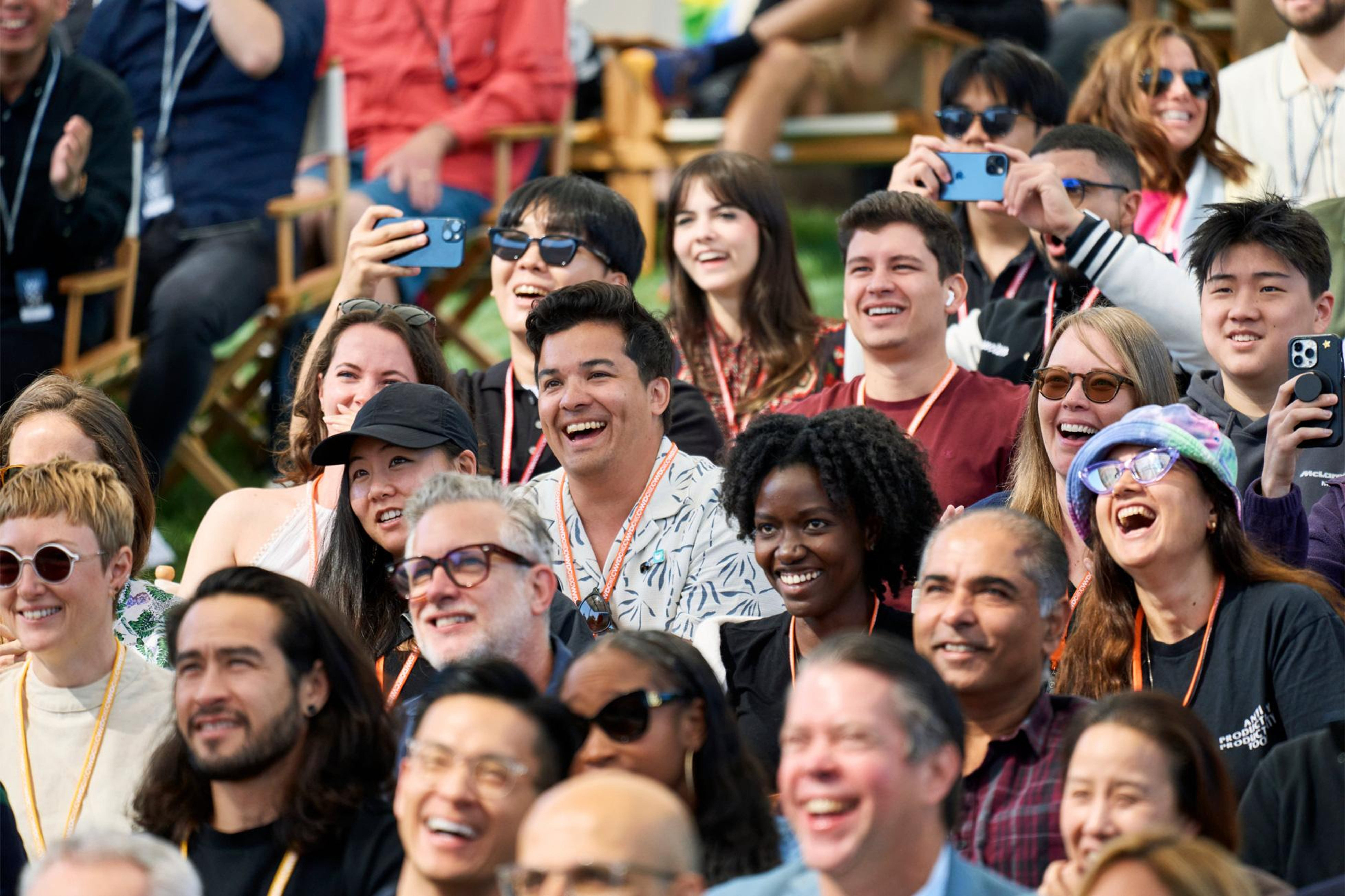 Seated outside of Caffè Macs at Apple Park, the crowd cheers during the WWDC24 keynote.