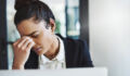 Shot of a young businesswoman looking stressed while working at her desk in a modern office