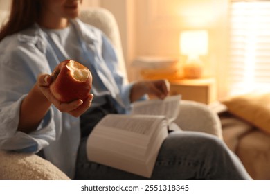 Libro de lectura de la mujer en casa, foco en la manzana