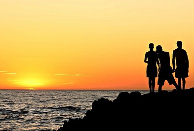 Silhouette von Menschen vor Sonnenuntergang am Meer in Marokko