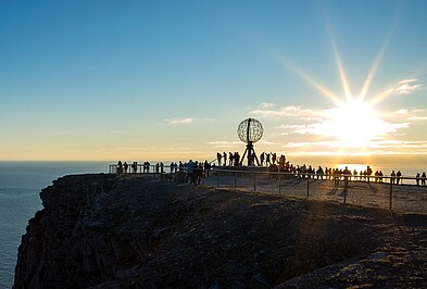 Sonne über dem Nordkap mit Globus in Norwegen