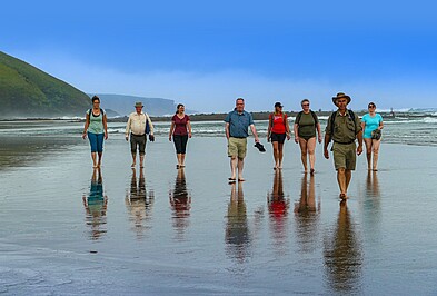 TARUK Reiseleiter Franz Malan mti Reisegruppe an einem Strand in Südafrika