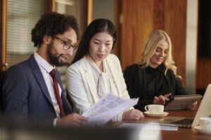 Three HR professionals discussing contract in a business meeting room