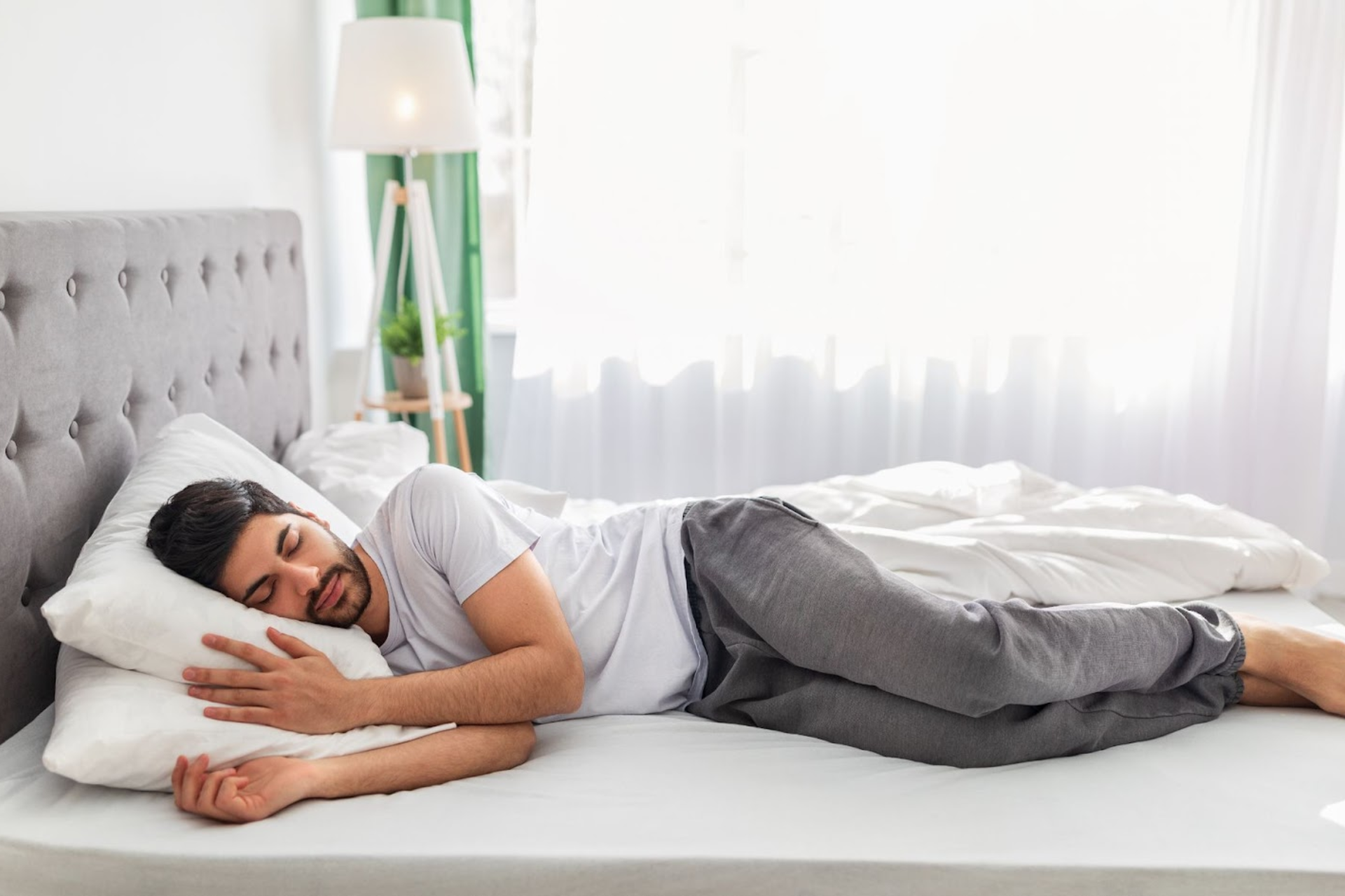 A man sleeping peacefully on his side in bed.