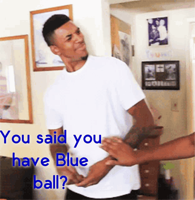 a man in a white shirt is being held by another man with the words " you said you have blue ball " below him