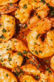 a close up of a pile of shrimp with sauce on them