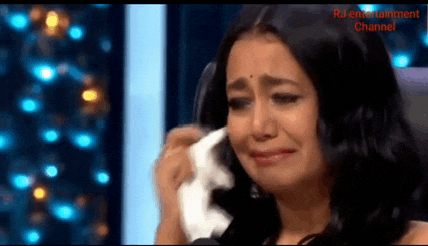 a woman is crying and wipes her face with a tissue .