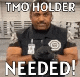 a security guard is standing in front of a sign that says tmo holder needed !