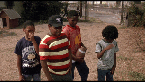 a boy wearing a raiders hat is standing next to a boy wearing a bulldog shirt