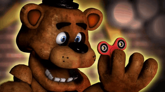 a brown teddy bear is holding a fidget spinner in his hand