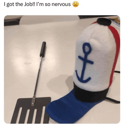 a hat with a blue anchor on it sits next to a spatula on a table