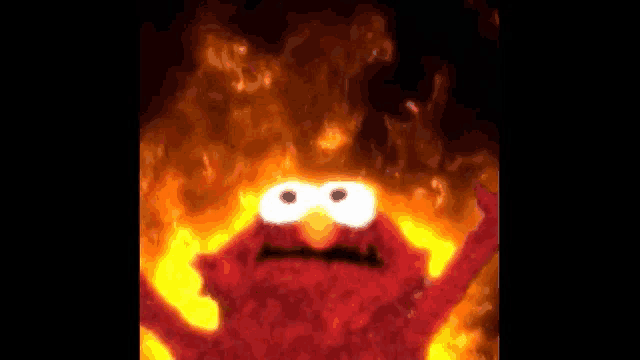 elmo from sesame street is standing in front of a fireball .