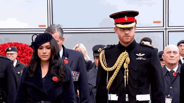 a man in a military uniform and a woman in a black coat are standing next to each other .