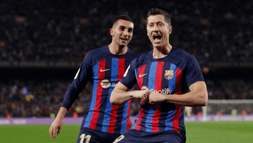 two soccer players wearing spotify jerseys are celebrating