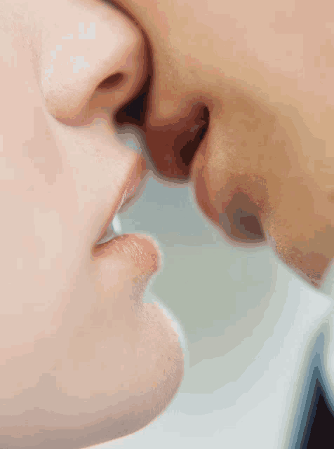 a close up of a man and a woman kissing each other