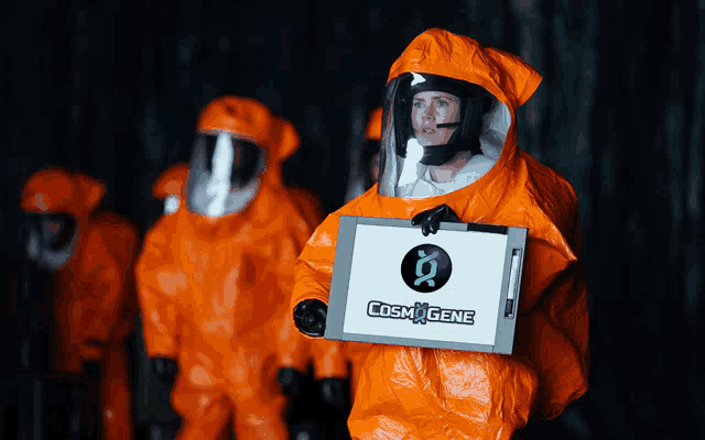 a woman in a protective suit is holding a box that says cosm gene