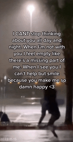 a person is walking down a street at night with a quote that says i cant stop thinking about you all day and night .