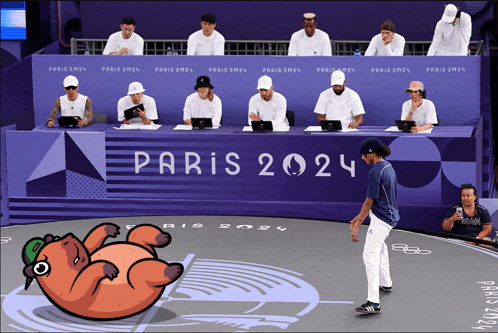 a group of people sitting at a table with paris 2024 on it