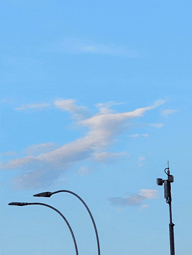 a street light is against a cloudy blue sky