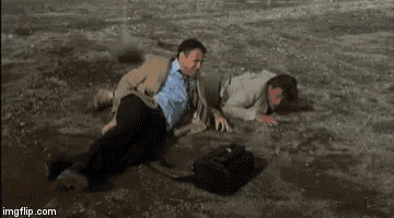 two men are laying on the ground in a puddle of water .