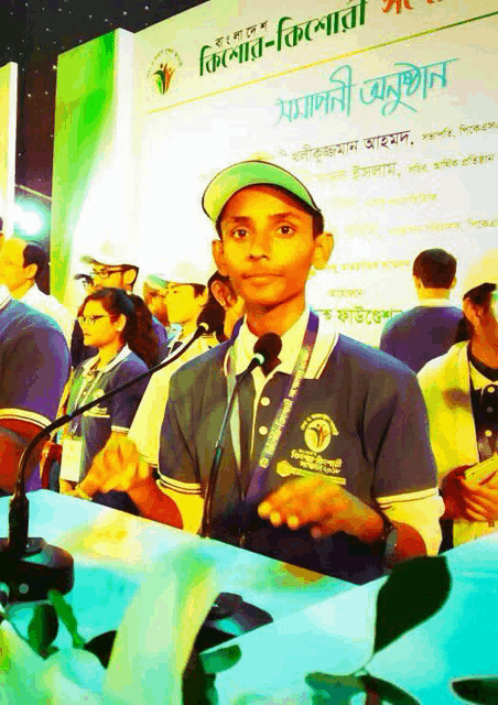 a boy speaking into a microphone with a sign behind him that says ' bangladesh '