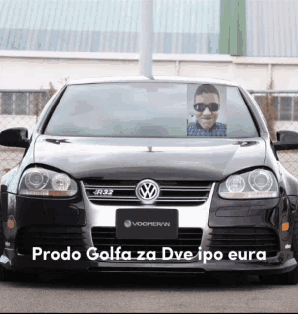 a black volkswagen with a picture of a man behind the windshield