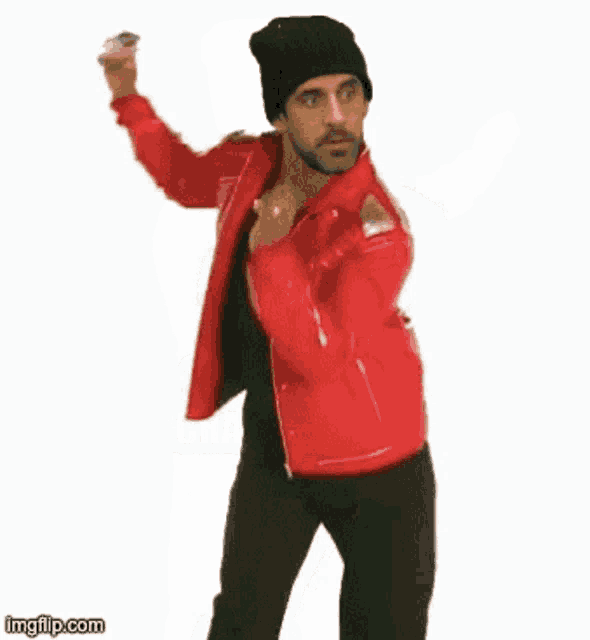 a man wearing a red jacket and a black hat is dancing with the words cha cha ar cha cha real smooth .