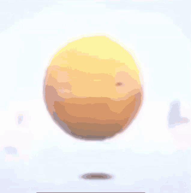 a yellow ball is floating in the air with a white background .