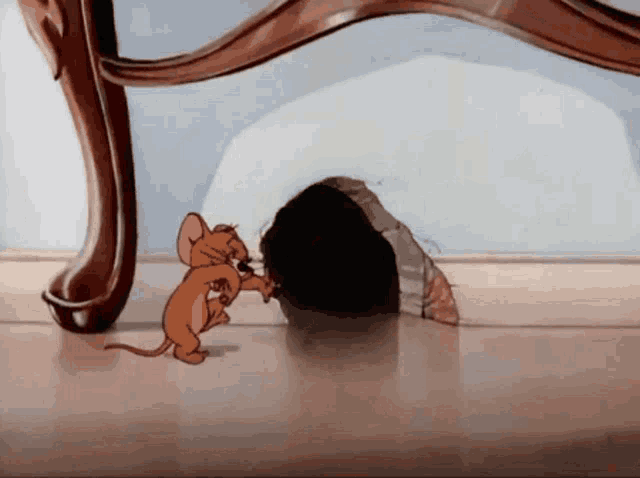 a cartoon mouse is standing next to a hole in the floor