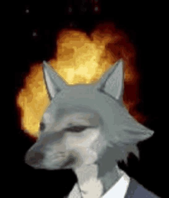 a wolf in a suit and tie is standing in front of a fire explosion .