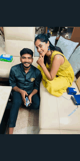 a man and woman are posing for a picture while sitting on a couch