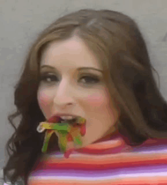 a woman in a striped sweater is eating a candy