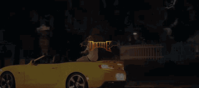 a yellow car is parked in front of a sign that says doobie on it