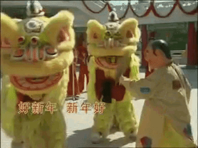 a group of lion dancers are performing in front of a sign that says ' chinese new year ' on it