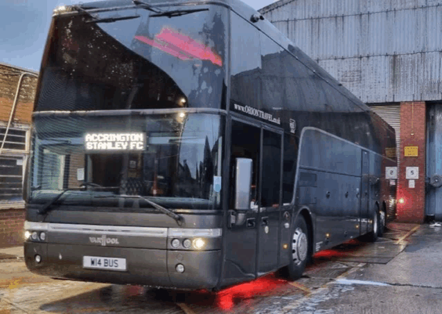 a black double decker bus with the words accrington stanley fc on the front