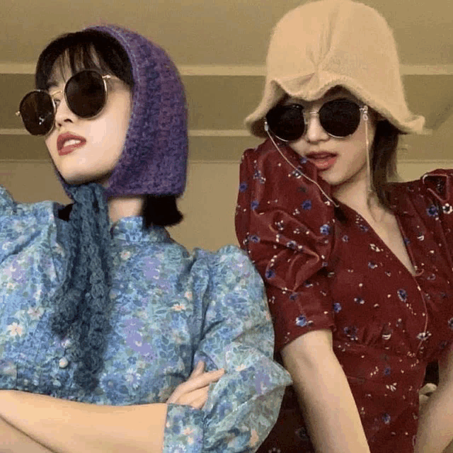 two women wearing hats and sunglasses are posing for a picture