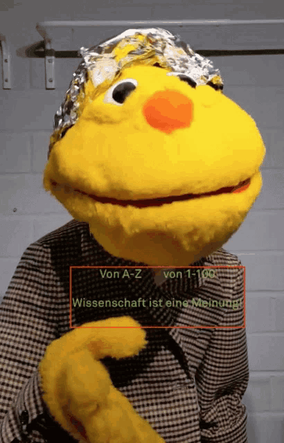 a yellow stuffed animal wearing a tin foil hat with the words von a-z von 1-100 wissenschaft ist eine meinung