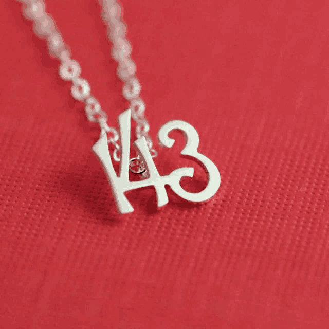 a necklace with the number 43 on it is on a red surface