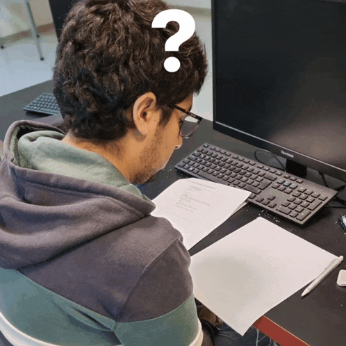 a man with a question mark on his head sits in front of a samsung computer