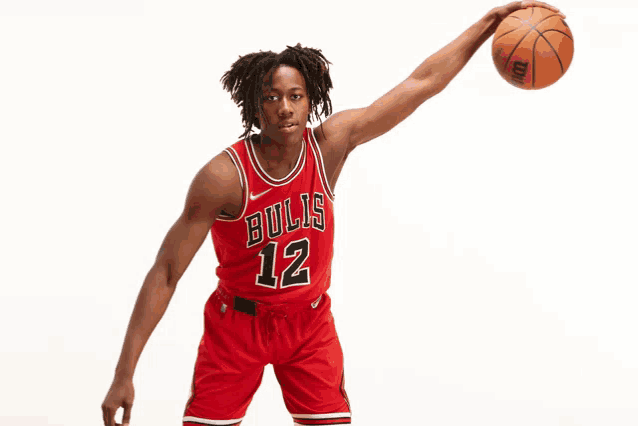 a basketball player for the bulls is holding a ball