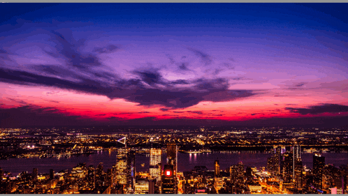 an aerial view of a city at sunset with a purple sky