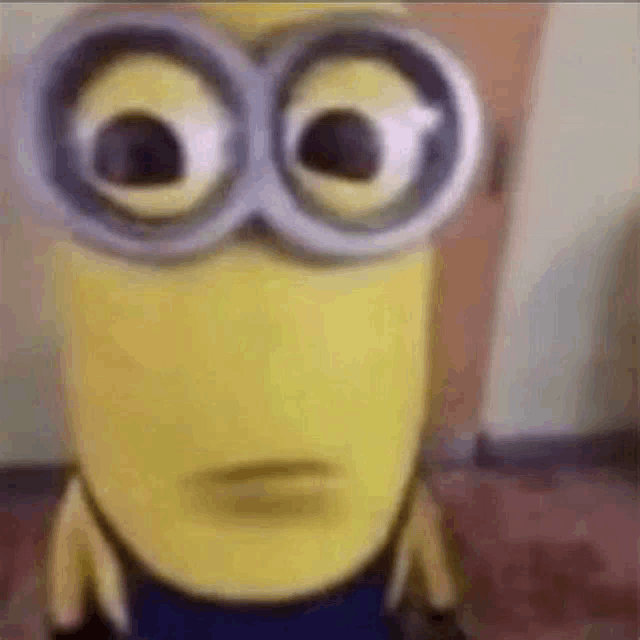 a close up of a minion wearing glasses with big eyes .