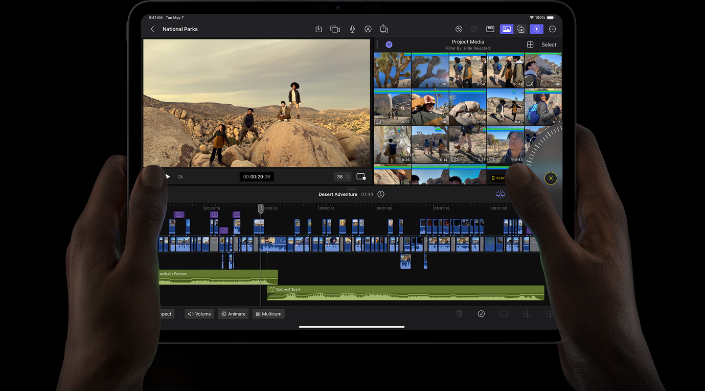 一双手拿着 iPad Pro，正在使用调节轮来浏览 iPad 版 Final Cut Pro 中的素材