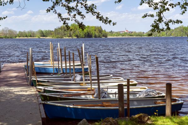 Abtsdorfer See mit Bootsanleger im Vordergrund und Leobendorfer Kirche im Hintergrund - © RoHa Fotothek