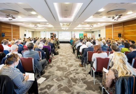 Around 150 guests seated in rows facing the stage at the front in the function room at Casa Hotel with sponsors