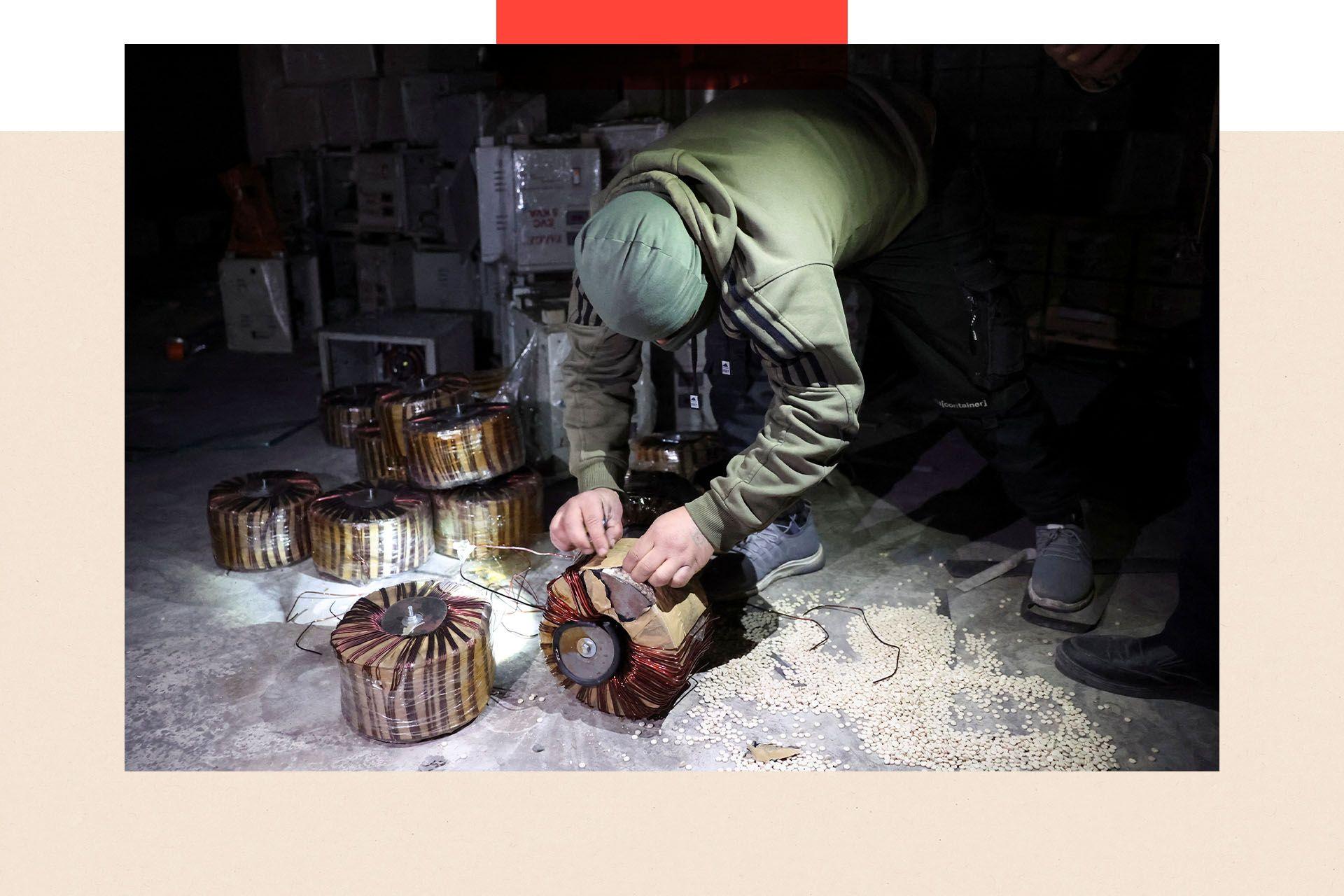 A treated image shows a men inspect electrical storage components,there are pills across the floor